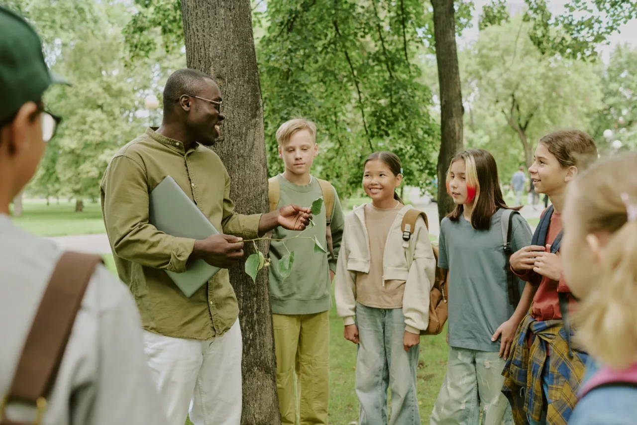 Teacher explaining plant biology to students during an outdoor GPS learning session
